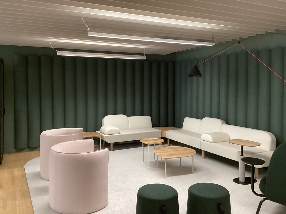 Wider angle of the same lounge showing the full baffle ceiling
