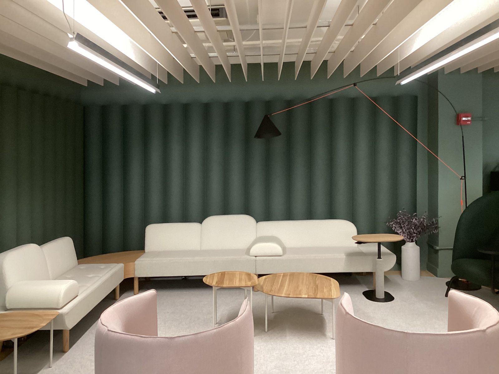 Scala XL panels in deep green behind lounge seating, with white Measure baffles overhead